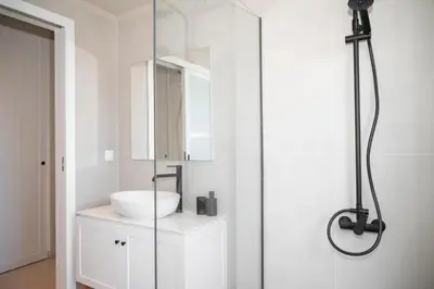 a white bathroom with a sink and a shower at Elia Suites in Falasarna