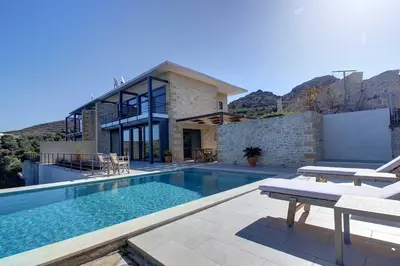 a house with a swimming pool in front of a house at Villa Simera, with pool & great view in Fournádhos