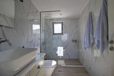 a bathroom with a sink and a toilet and a shower at Villa Simera, with pool & great view in Fournádhos