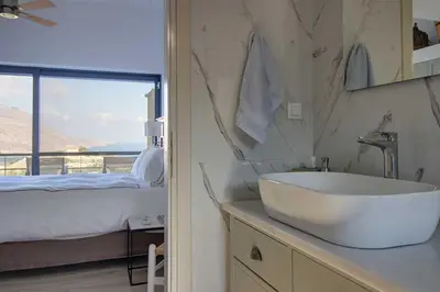 a bathroom with a sink and a bed with a window at Villa Simera, with pool & great view in Fournádhos