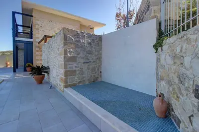 a stone wall with a bench on a patio at Villa Simera, with pool & great view in Fournádhos