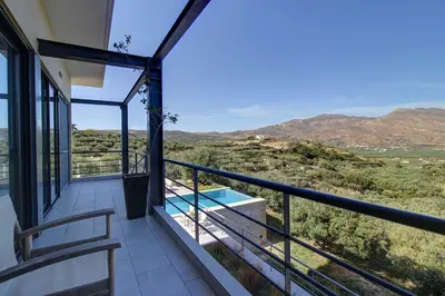 a balcony of a house with a view of the mountains at Villa Simera, with pool & great view in Fournádhos