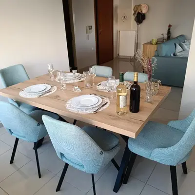 a wooden table with blue chairs and a bottle of wine at Del's Apartment in Chania Town