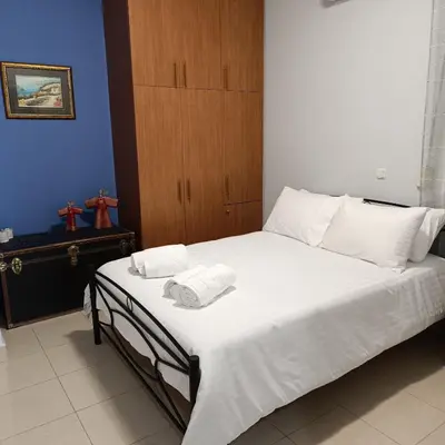 a bedroom with a bed with white sheets and pillows at Del's Apartment in Chania Town