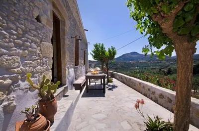 a patio with a table and some plants on a building at Kallimento-Dimitra in Kissamos