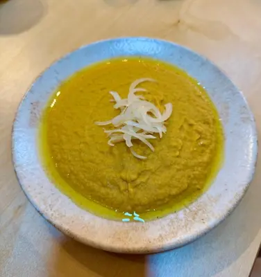 a plate with a bowl of soup on a table at WHITE MOUNTAINS Nature Home in Arménoi
