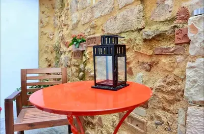 a red table with a lantern on it next to a stone wall at Casa Di Porto Vecchio in Chania Town