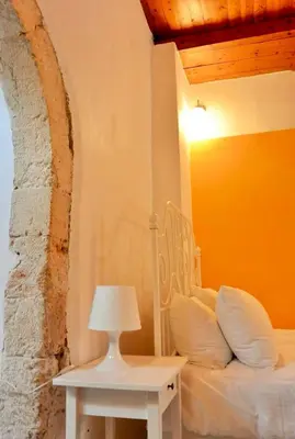 a bedroom with a bed and a table with a lamp at Casa Di Porto Vecchio in Chania Town