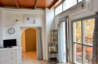 a living room with a clock on the wall and a window at Casa Di Porto Vecchio in Chania Town