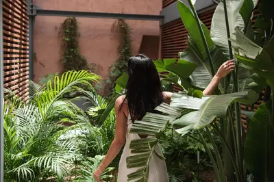a woman in a white dress looking at plants at Elysia Boutique Hotel in Chania Town