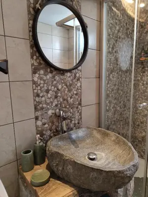 a bathroom with a stone sink and a mirror at Sea Sight Vibes in Frangokastello