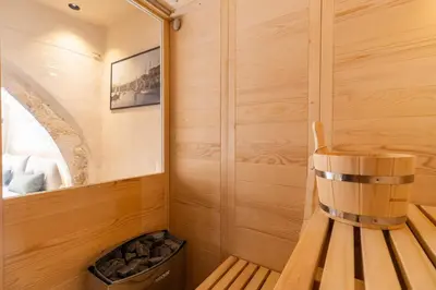 a small sauna with a wooden bench and a trash can at Mimosa Veneziano - Sauna - Old Town Chania in Chania Town