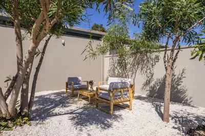 two chairs and a table next to some trees at Natura Hill Villa II Sunset View in Kounoupidhianá