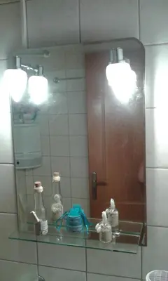 a mirror in a bathroom with bottles on a sink at Gradma Katina in Plataniás
