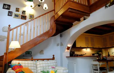 a living room with a couch and a staircase at Rock House's Villa Melody in Plataniás