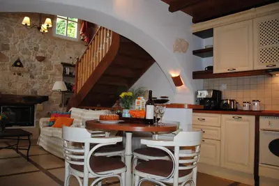a kitchen with a table and chairs in a room at Rock House's Villa Melody in Plataniás