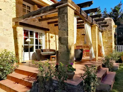 a wooden deck with a pergola on a house at Rock House's Villa Melody in Plataniás