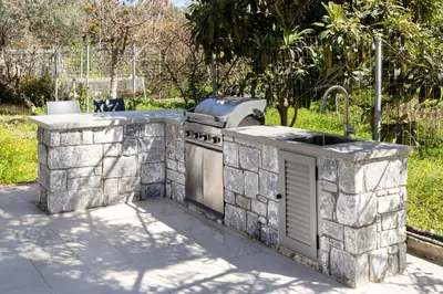 a stone kitchen with a stove in a yard at Anassa Natura Villa in Daratso
