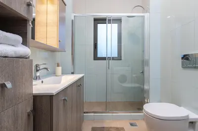 a bathroom with a shower and a toilet and a sink at Anassa Natura Villa in Daratso