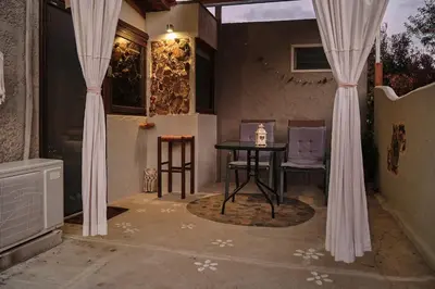 a table and chairs in a room with curtains at theVotsalo Eco house in Agios Padeleimon