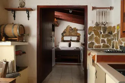 a kitchen with a room with a bed and a door at theVotsalo Eco house in Agios Padeleimon
