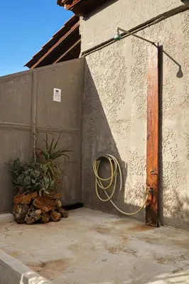 a hose hooked up to a wall with a plant at theVotsalo Eco house in Agios Padeleimon