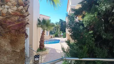 a view of a courtyard with a pool and palm trees at Relax Holiday Villa in Maleme