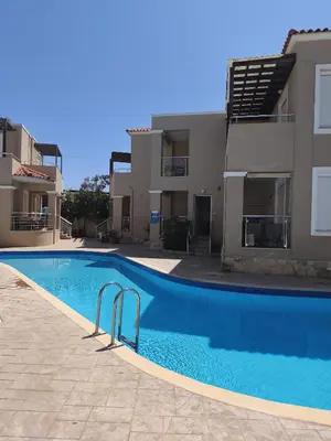 a swimming pool in front of a building at Relax Holiday Villa in Maleme