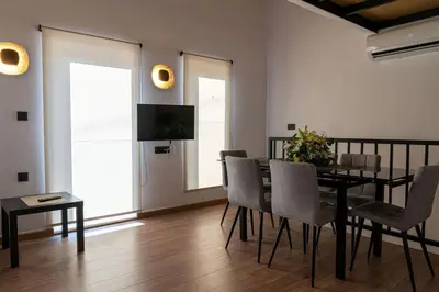 a dining room with a table and chairs and a television at Sappho 3-bedroom House in Daratso