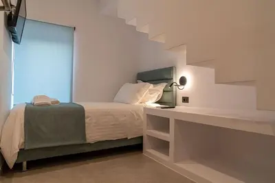 a bedroom with a bed and a staircase at Sappho 3-bedroom House in Daratso