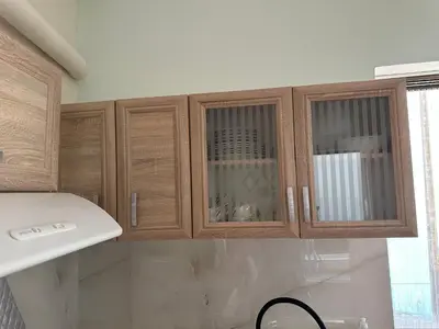 a kitchen with wooden cabinets and a white counter top at Haris home 1 in Chania Town