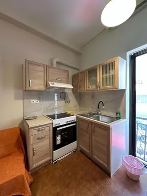 a kitchen with wooden cabinets and a stove and a sink at Haris home 1 in Chania Town
