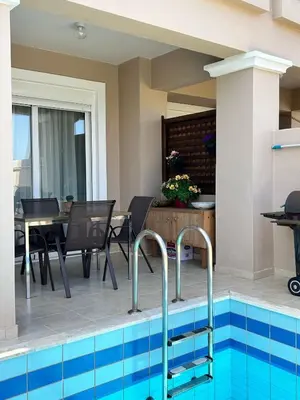 a swimming pool with a table and chairs next to a house at Relax Private Pool House in Maleme