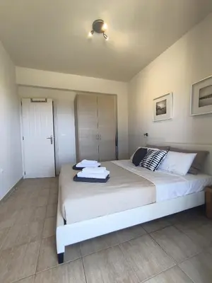 a bedroom with a large white bed with towels on it at Relax Private Pool House in Maleme