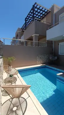 a pool with a table and a chair next to it at Relax Private Pool House in Maleme