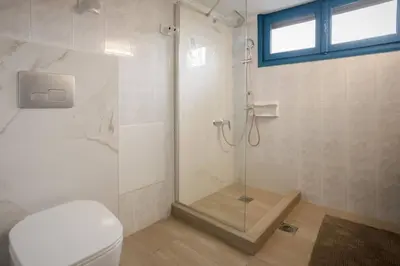 a bathroom with a shower and a toilet at Halases Panorama Villa pvt pool in Alikampos