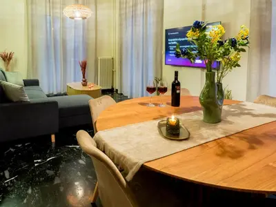 a table with a vase of flowers and wine glasses at Atenà Urban Living in Chania Town
