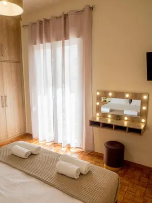 a bedroom with a bed with two towels and a mirror at Atenà Urban Living in Chania Town