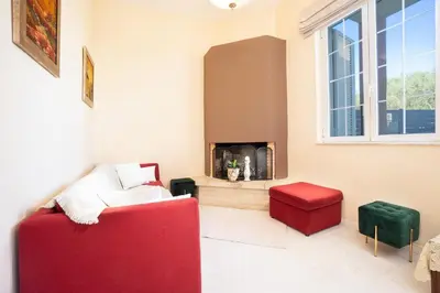 a living room with a red couch and a fire place at Casa BI LA in Galatás