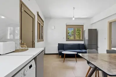 a kitchen and living room with a couch and a table at AURA - Deluxe Apartment in Chania Town