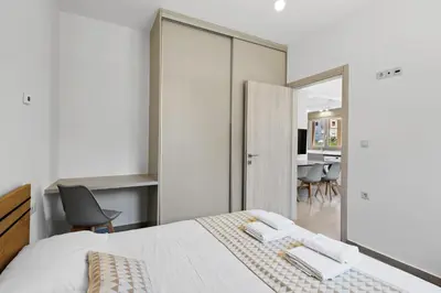 a bedroom with a bed and a desk with chairs at AURA - Deluxe Apartment in Chania Town