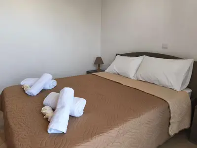 a bedroom with a bed with towels on it at Van Gogh & Monet apartments in Maleme