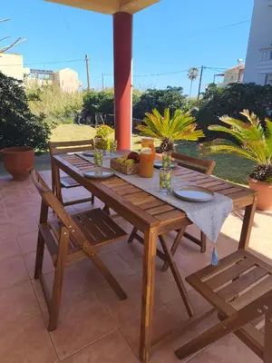 a wooden table and chairs on a patio at Van Gogh & Monet apartments in Maleme