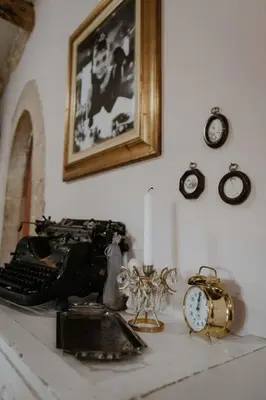 a desk with a typewriter and clocks on a wall at Ewa's Cretan Vintage Houses in Kharkhalianá
