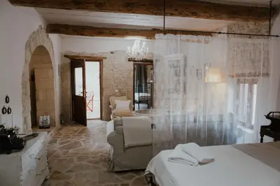 a bedroom with a bed and a living room at Ewa's Cretan Vintage Houses in Kharkhalianá