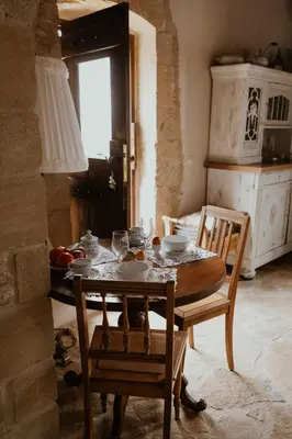 a dining room with a table and chairs and a window at Ewa's Cretan Vintage Houses in Kharkhalianá