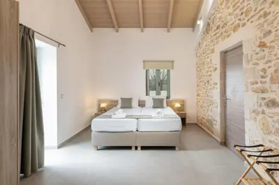 a bedroom with a bed and a stone wall at Villa Lakioto in Dhémbla