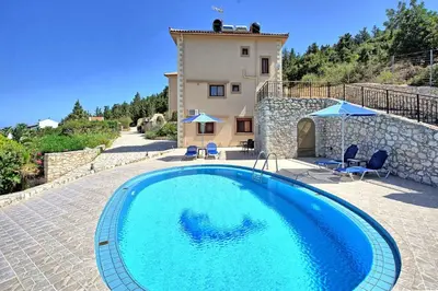 a large blue swimming pool in front of a house at Villa Halepi by PosarelliVillas in Gavalochori