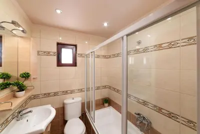 a bathroom with a shower and a toilet and a sink at Villa Halepi by PosarelliVillas in Gavalochori