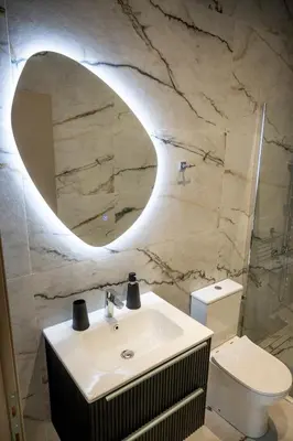 a bathroom with a sink and a mirror and a toilet at Breezy Sea View Appartment in Chania Town
